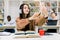 Attractive happy young girl student, wearing casual clothes and hipster earphones, sitting at the desk with books