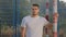 Attractive Hispanic guy in summer sportswear posing at stadium standing at soccer goal. Serious sportsman, coach