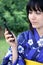 Attractive Japanese in a kimono with cellphone