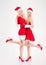 Attractive joyful women in santa claus costumes standing and smiling