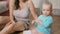 Attractive kid draws a pencil on the floor with mom at home. The boy is smiling and playing with his mother. The concept