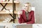 Attractive light woman with deep blue eyes sitting at the wooden desk