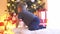 Attractive little boy decorating Christmas tree with balls and lights. Kid preparing for the New Year at home.