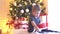 Attractive little boy unwrapping Christmas gifts. Kid opening New Year presents at home.