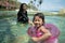 Attractive little girl and her mother swimming