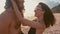 Attractive, in love, beautiful young travel couple enjoying sunset on the beach kissing and hugging in slow motion. Sea
