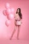 Attractive love teen brunette with balloons holding bouquet of r
