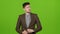 Attractive male businessman adjusts his clothes, wipes his face, admires himself. Green screen