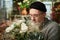 Attractive male florist sniffing white rose flower bouquet