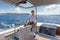 Attractive male skipper navigating the fancy catamaran sailboat on sunny summer day on calm blue sea water.