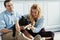 Attractive man and blonde woman sitting on floor in kitchen