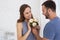 Attractive man gifting flowers to pregnant woman