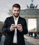 Attractive man plays with his smart phone in front of the Brandenburger Gate