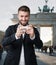 Attractive man plays with his smart phone in front of the Brandenburger Gate
