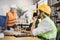 Attractive man in reflective vest sitting at table with males architects in uniform and helmets