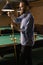 Attractive man snooker, billiard player, chalking the cue in motion with chalk. Professional hand billiard cue ball hand