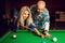 Attractive man teaches Woman begins the game on the pool table