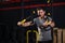 Attractive man training with tex strap in the sport fitness gym club. Black background with copy space. Trains the upper body