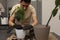 An attractive man transplanted an avocado seedling into a new, larger pot