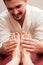 Attractive masseur smiling and massaging woman feet and soles