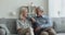 Attractive mature couple lead conversation seated on sofa