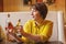 Attractive mature woman holding olive oil and balsamic vinegar bottles in italian trattoria