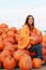 Attractive mature woman with orange pumpkins in autumn