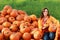 Attractive mature woman with orange pumpkins in autumn