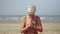 Attractive mature woman practicing meditation and yoga on the sea beach
