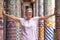 Attractive mature woman standing among the colorful mosaic columns of a historic building in Barcelona. Smiling female with open