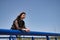 Attractive mature woman, in transparent black shirt, leaning on a railing looking pensively into nothingness. Concept maturity,