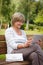 Attractive mature woman using digital tablet in a park