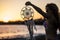 Attractive middle age caucasian woman take a dreamcatcher hand made. outdoor beach sunset time coloured scenic leisure activity.