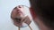 An attractive middle-aged man combing his beard in front of a mirror. Natural look, freckles, beard with gray hair. Back