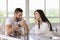 Attractive millennial couple drink tea seated at table in cafe