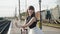 Attractive model smiling, poses with lush skirt at suitcase on railway platform