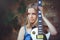 Attractive modest young blond woman with a white guitar in hand holding a wall background shy and inquisitive