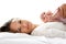 Attractive mother lying in bed with newborn baby