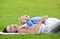 Attractive mother lying down on grass with daughter