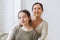Attractive mother middle age woman and daughter teenager together in the light interior