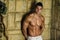 Attractive muscleman against rough wall