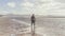 Attractive muscular bearded man standing on the sea shore at sunrise. Side portrait of healthy young bearded man running