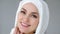 Attractive muslim woman wearing hijab is looking at camera and smiling.