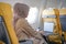 Attractive muslim women passengers working on laptop sitting near window in an airplane.