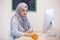 Attractive Muslim young woman working in office on computer