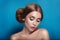 Attractive mysterious young woman with double hair bun in Princess Leia hairstyle looks towards the camera