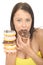 Attractive Natural Young Woman Eating a Pile of Iced Donuts