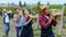 Attractive old man farmer and his countryside team in the middle of vineyard walking in front of the camera holding some