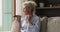 Attractive older woman holds smartphone talks on speakerphone