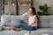 Attractive pensive woman resting on couch alone in living room